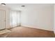 Cozy carpeted living room with large window, bright neutral walls and front door at 12246 W Bloomfield Rd, El Mirage, AZ 85335