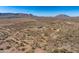 Expansive aerial view showcases the desert landscape surrounding a modern home and outbuilding at 13502 E Jomax Rd, Scottsdale, AZ 85262