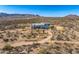 Aerial view of a modern house with a patio, native desert vegetation, and winding dirt roads at 13502 E Jomax Rd, Scottsdale, AZ 85262