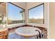 Bathroom soaking tub next to corner windows showcasing gorgeous mountain views at 13502 E Jomax Rd, Scottsdale, AZ 85262