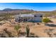 Expansive desert home featuring a neutral color palette, well-designed patio, and a backdrop of mountains at 13502 E Jomax Rd, Scottsdale, AZ 85262