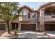 Three-story townhouse with brown trim, arched windows, attached garages, and mature landscaping at 14000 N 94Th St # 1118, Scottsdale, AZ 85260