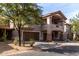 Three-story townhouse with brown trim, arched windows, attached garages, and mature landscaping at 14000 N 94Th St # 1118, Scottsdale, AZ 85260