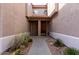 Pathway leads to a charming front entryway with a wooden front door framed by desert landscaping at 14000 N 94Th St # 1118, Scottsdale, AZ 85260