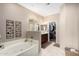 Bright bathroom features a soaking tub, walk-in closet, neutral color scheme, and decorative accents at 14000 N 94Th St # 1118, Scottsdale, AZ 85260