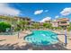 Resort-style pool with spa, surrounded by lush landscaping and multi-story condo buildings under sunny skies at 14000 N 94Th St # 1118, Scottsdale, AZ 85260