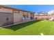 Spacious backyard with a covered patio, artificial turf, and ample seating perfect for outdoor gatherings at 14296 W Surrey Dr, Surprise, AZ 85379