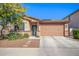 Charming single-story home featuring a desert landscape, a two-car garage, and a stone-accented facade at 14296 W Surrey Dr, Surprise, AZ 85379