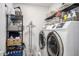 Convenient laundry room with modern washer and dryer, plus ample storage shelving for organization at 14296 W Surrey Dr, Surprise, AZ 85379