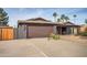 Single-story home featuring a two-car garage, and bikes out front at 15034 N 54Th St, Scottsdale, AZ 85254