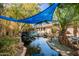 Beautiful backyard with a tranquil pond featuring a small waterfall and lush greenery, and a partial pool view at 1541 E Hope St, Mesa, AZ 85203