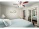 Well-lit bedroom featuring wood floors, ceiling fan, and mirrored closet doors at 1541 E Hope St, Mesa, AZ 85203