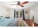 Bright bedroom featuring a ceiling fan, hardwood floors, and French doors to the exterior at 1541 E Hope St, Mesa, AZ 85203