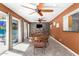 Dining area with stone accent wall, three ceiling fans, tiled floor, and sliding door access to the backyard at 1541 E Hope St, Mesa, AZ 85203