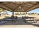 Picnic tables inside a park pavilion, with a playground visible in the distance at 1541 E Hope St, Mesa, AZ 85203