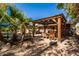 Covered patio with stone accents, seating area, and a view of the lush landscape at 1541 E Hope St, Mesa, AZ 85203