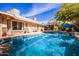 Backyard pool with a stone patio and lush landscaping surrounding the pool area at 1541 E Hope St, Mesa, AZ 85203