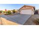 Inviting single-story home showcasing a neutral stucco facade, tile roof and a spacious concrete driveway at 15601 W Hammond Dr, Goodyear, AZ 85338