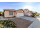 Attractive single-story home featuring a neutral stucco facade, tile roof, desert landscaping and long driveway at 15601 W Hammond Dr, Goodyear, AZ 85338