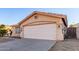 Inviting single-story home showcasing a neutral stucco facade, tile roof and a spacious concrete driveway at 15601 W Hammond Dr, Goodyear, AZ 85338