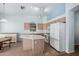 Kitchen featuring white appliances, light wood cabinets and a center island at 15601 W Hammond Dr, Goodyear, AZ 85338