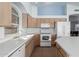 Kitchen featuring white appliances, light wood cabinets and tile floors at 15601 W Hammond Dr, Goodyear, AZ 85338