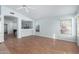 Bright living room with wood floors, two windows and a ceiling fan at 15601 W Hammond Dr, Goodyear, AZ 85338