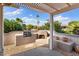 This covered patio includes a built-in BBQ, fireplace, and seating at 16200 W Hearthstone Dr, Surprise, AZ 85374