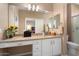 Bathroom with a granite countertop, double sinks, decorative mosaic backsplash, and a large mirror at 16200 W Hearthstone Dr, Surprise, AZ 85374