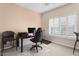 Home office featuring a computer desk, gaming chair, and natural light from the shuttered windows at 16200 W Hearthstone Dr, Surprise, AZ 85374