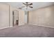 Large bedroom featuring neutral carpet, ceiling fan, and access to the bathroom at 17192 W Post Dr, Surprise, AZ 85388