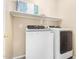 Laundry room with modern washer and dryer and open shelving for storage at 17192 W Post Dr, Surprise, AZ 85388