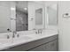 Beautiful bathroom with a double sink vanity, large mirror and stylish tiled shower at 1811 N Brower Ln, Maricopa, AZ 85139