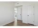 Bright bedroom with wood look floors and view into the kitchen at 1811 N Brower Ln, Maricopa, AZ 85139