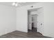 A neutral toned bedroom with wood look floors and a door to the bathroom at 1811 N Brower Ln, Maricopa, AZ 85139