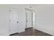 Bedroom with wood-look floors and white trim, showing access to other rooms at 1811 N Brower Ln, Maricopa, AZ 85139