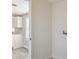 An interior view of a laundry room with access to the kitchen featuring white cabinets at 1811 N Brower Ln, Maricopa, AZ 85139