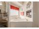 Relaxing soaking tub with glass block window and fireplace in well-lit bathroom at 1831 W San Angelo St, Gilbert, AZ 85233