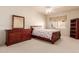 Bedroom featuring light tan carpet, a wooden bed frame, and a large mirror at 1831 W San Angelo St, Gilbert, AZ 85233