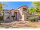 Inviting two-story home featuring a decorative fountain, desert landscaping, and a well-manicured lawn at 1831 W San Angelo St, Gilbert, AZ 85233