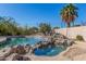 Beautiful backyard pool with rock features, a lush green landscape and a peaceful, private setting for relaxation at 1831 W San Angelo St, Gilbert, AZ 85233