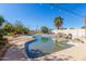 Inviting pool with rock feature surrounded by lush landscaping provides a refreshing escape in a serene backyard setting at 1831 W San Angelo St, Gilbert, AZ 85233