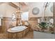 Bathroom showcasing a bathtub, decorative travertine tile, a granite vanity, and decorative fixtures at 23415 S 202Nd St, Queen Creek, AZ 85142