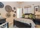 Bedroom with a dark wood bed frame, decorative wall hangings, and a window providing natural light creating a relaxing space at 23415 S 202Nd St, Queen Creek, AZ 85142