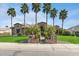 Elegant stone home with a circular entryway, palm trees, and a well-maintained front lawn at 23415 S 202Nd St, Queen Creek, AZ 85142