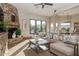 Open-concept living room with a stone fireplace and sliding doors to the backyard at 23415 S 202Nd St, Queen Creek, AZ 85142