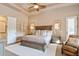 A primary bedroom featuring tray ceiling, ceiling fan, and a wooden bed frame at 23415 S 202Nd St, Queen Creek, AZ 85142