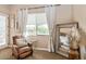 Bedroom detail showcasing a cozy chair, side table, large window, and an ornate floor mirror at 23415 S 202Nd St, Queen Creek, AZ 85142