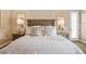 A well-lit main bedroom featuring a decorative headboard with carved mirrors and two side tables with lamps at 23415 S 202Nd St, Queen Creek, AZ 85142