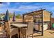 Outdoor dining area with pergola, string lights, hot tub, and privacy wall at 2463 E Stacey Rd, Gilbert, AZ 85298